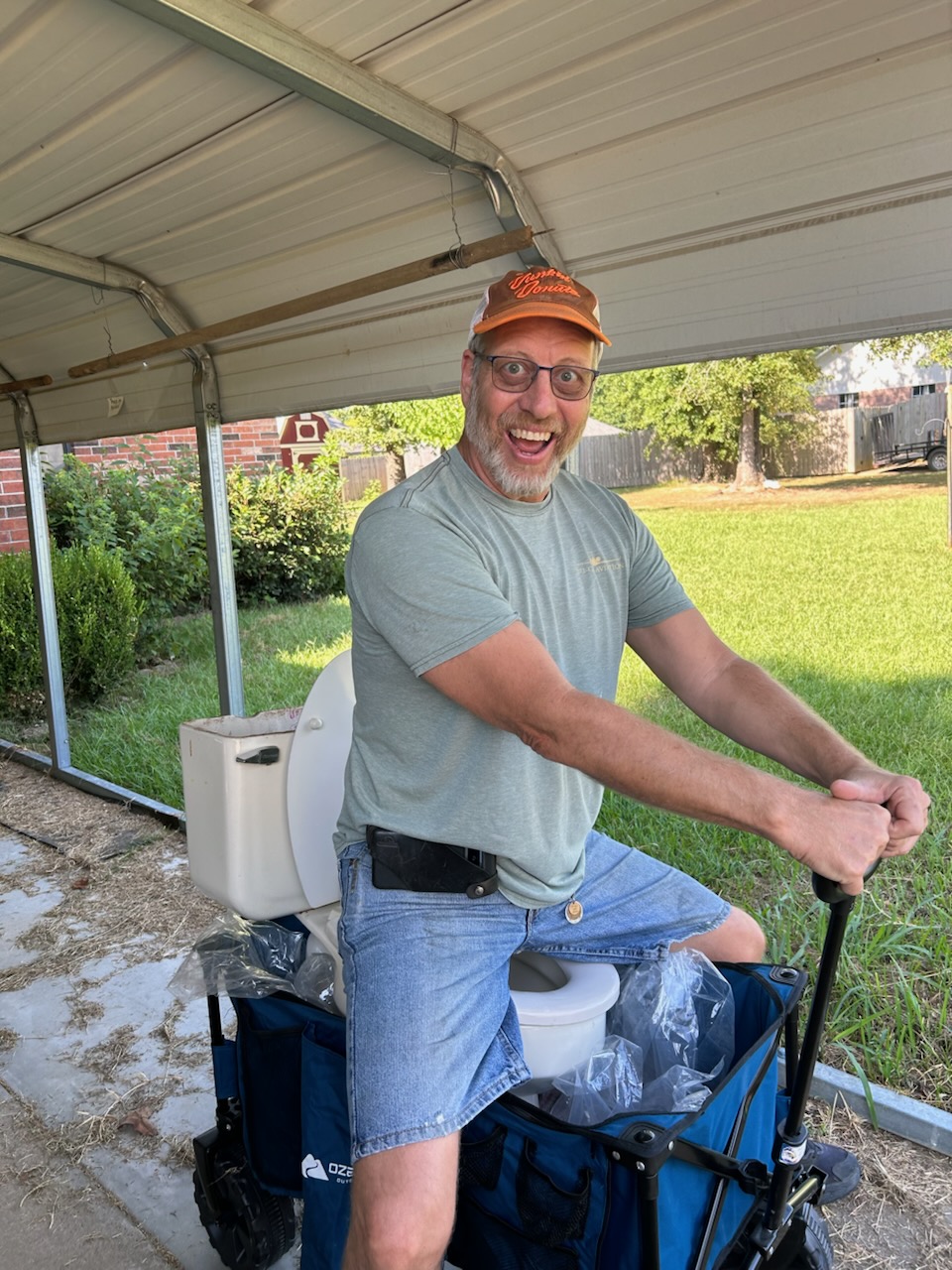 Happy man sitting on a toilet on a wagon