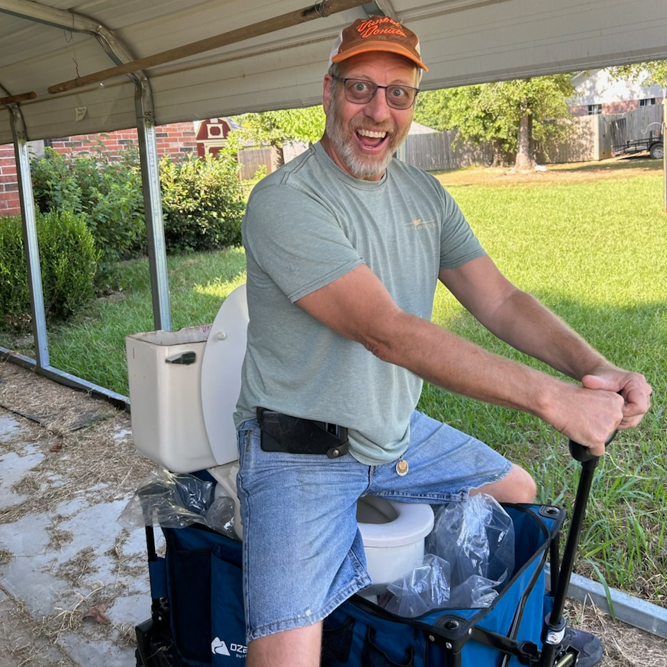 Happy man sitting on a toilet on a wagon