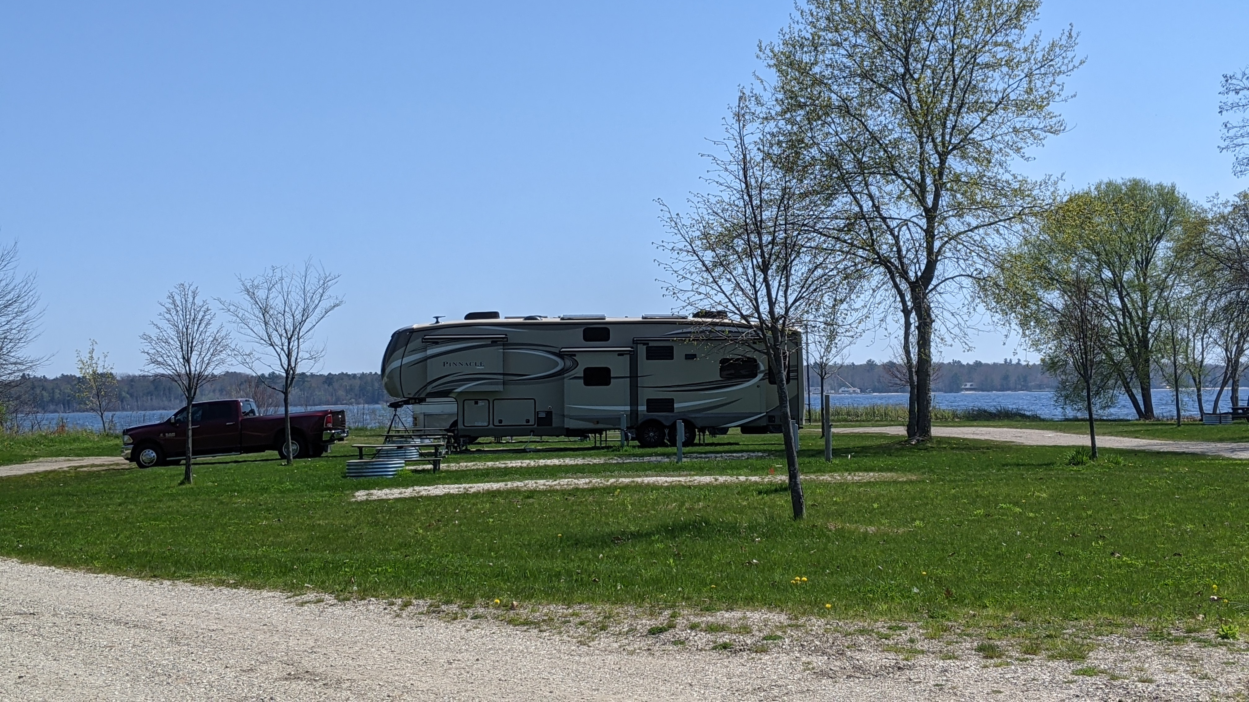 A truck and fifth wheel at a campground on a lake