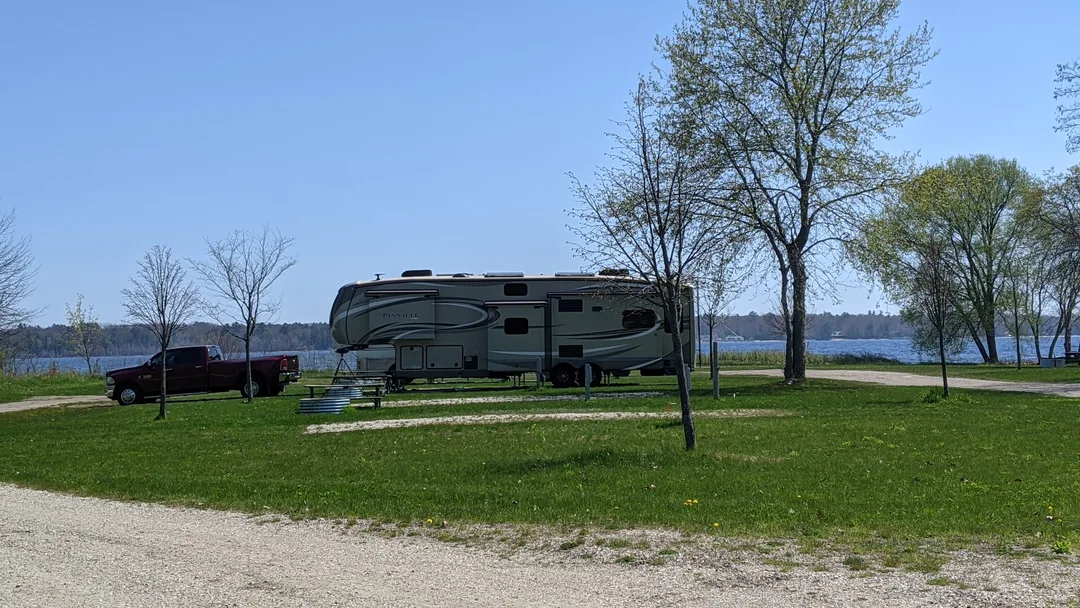 A truck and fifth wheel at a campground on a lake