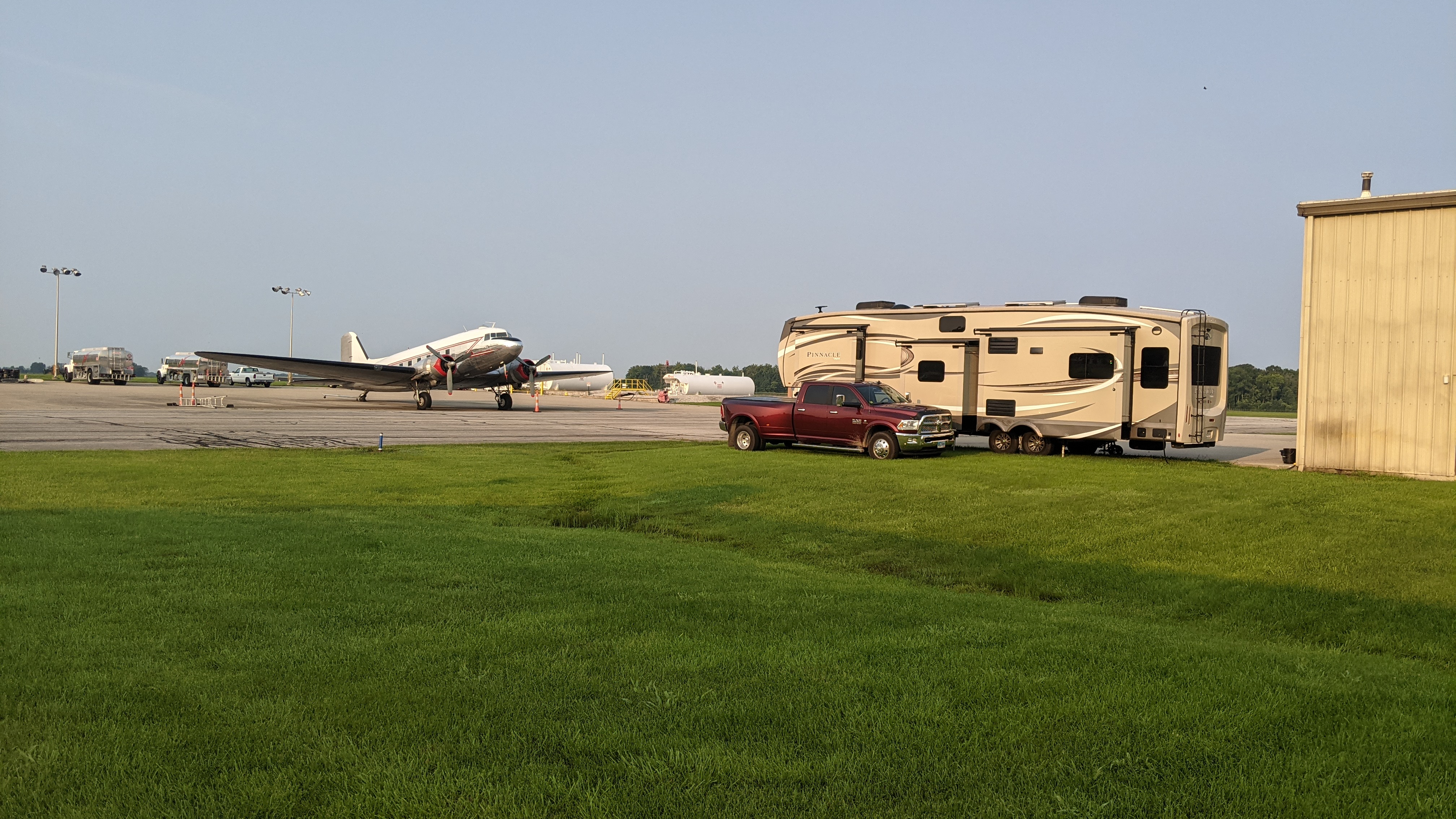A fifth wheel RV parked near an airplane