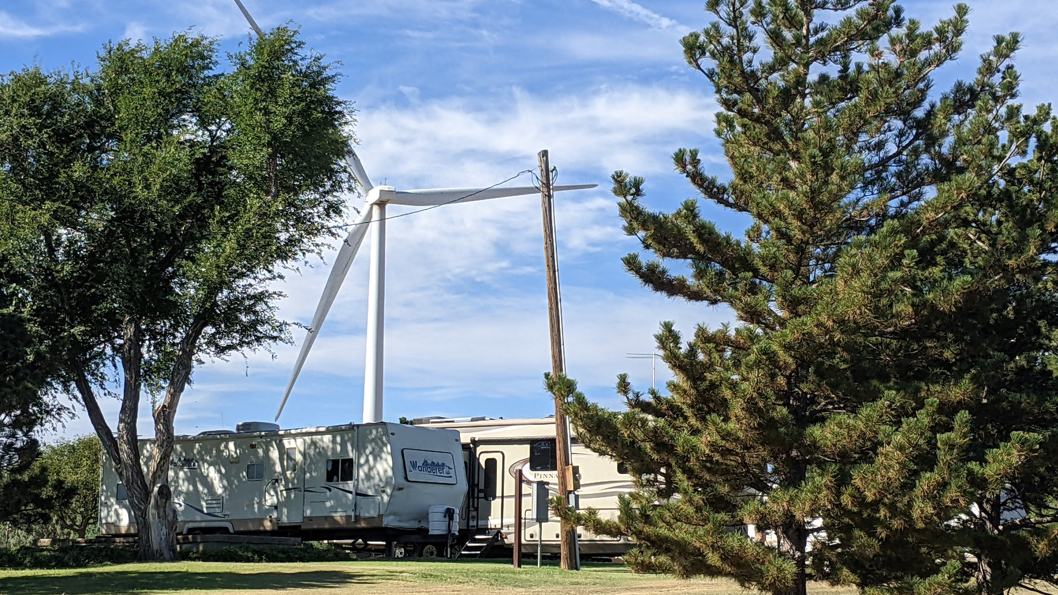 Two campers under a wind turbine