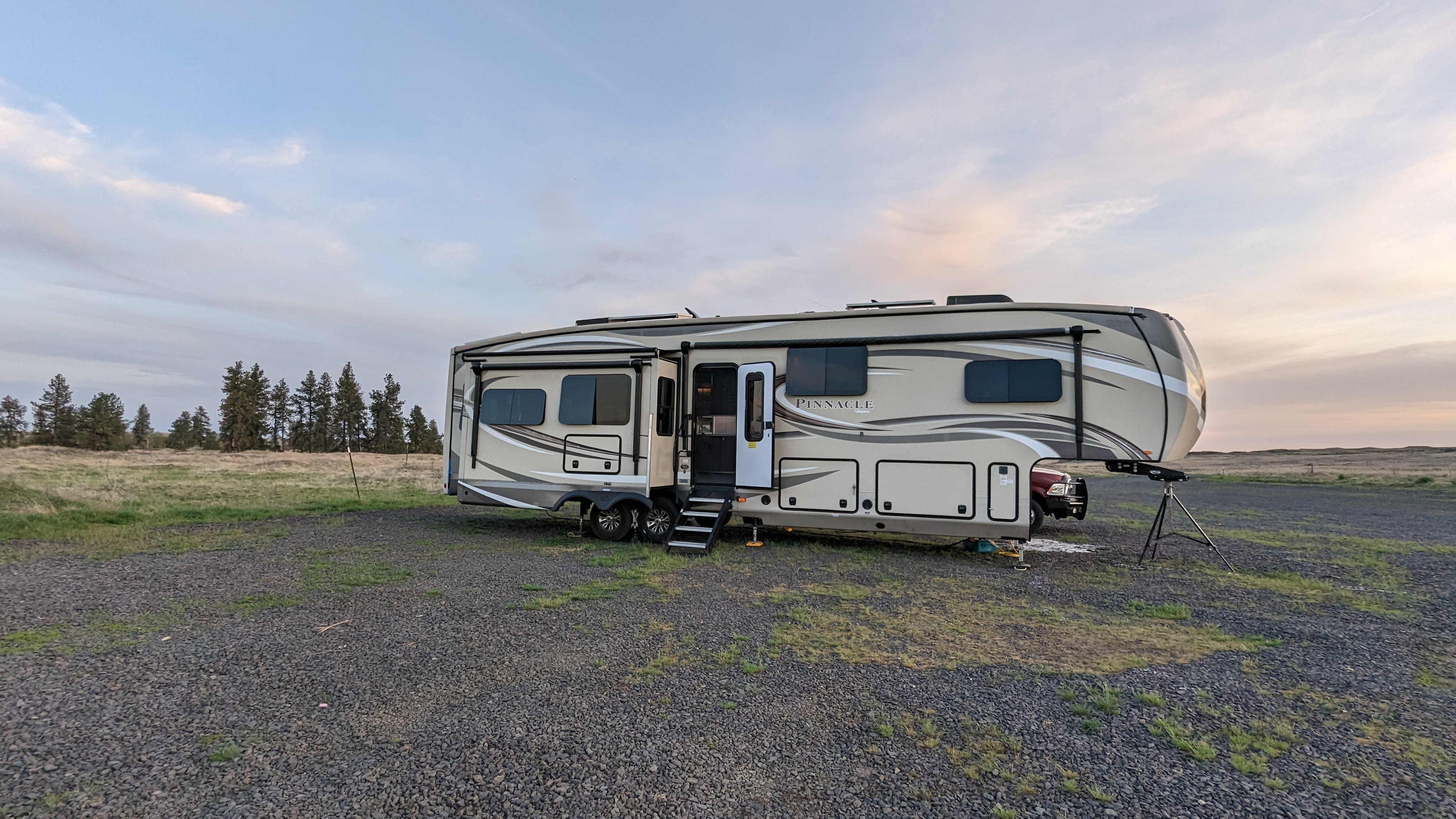 A sole fifth wheel RV on gravel at dusk