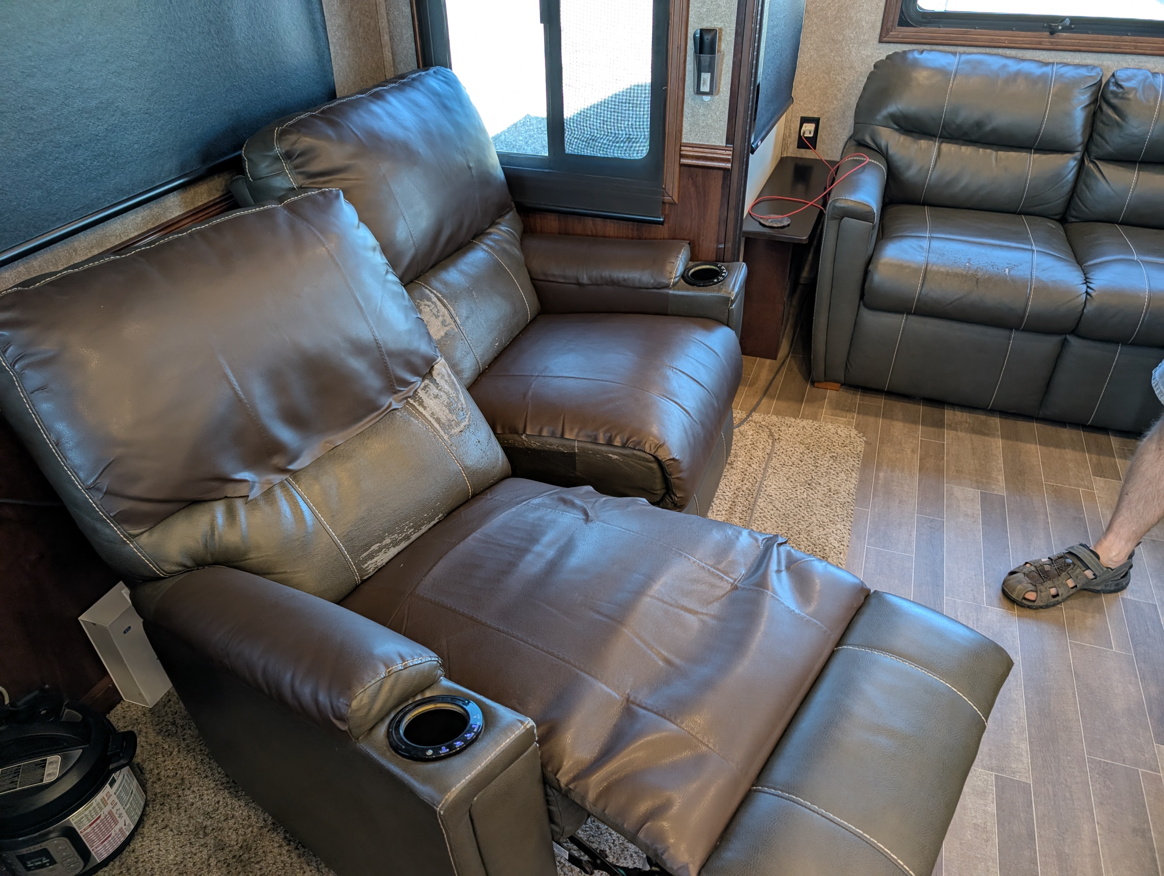 A couch and reclining theater seat inside an RV