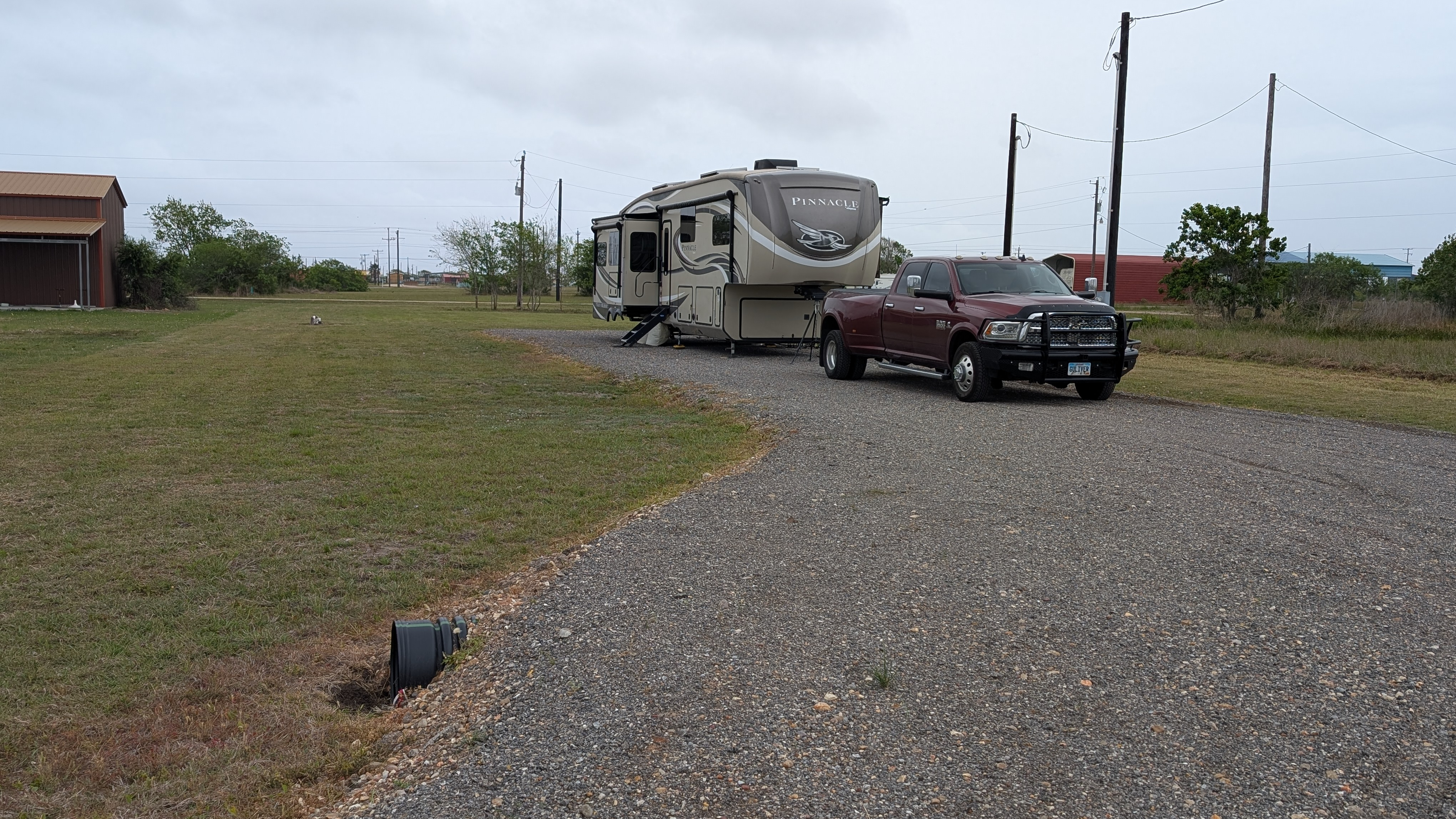 A truck and RV on a long gravel driveway in Texas
