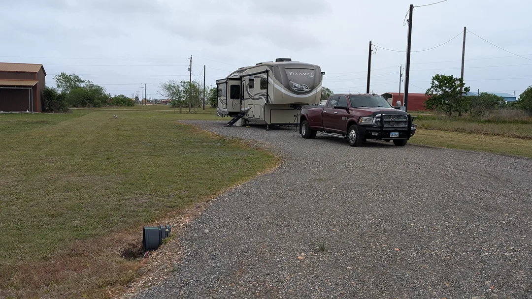 A truck and RV on a long gravel driveway in Texas