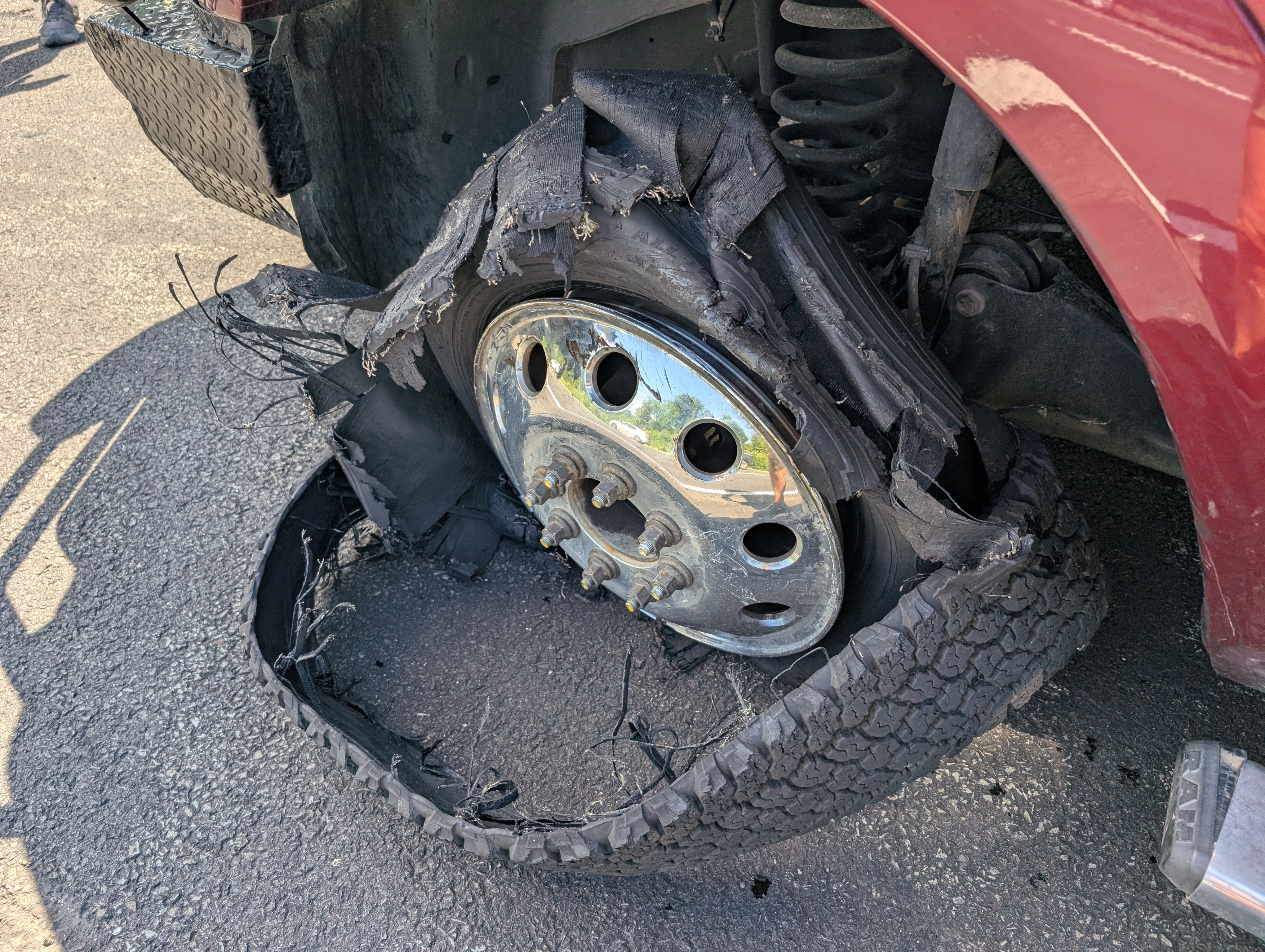 A shredded tire on the front of a truck