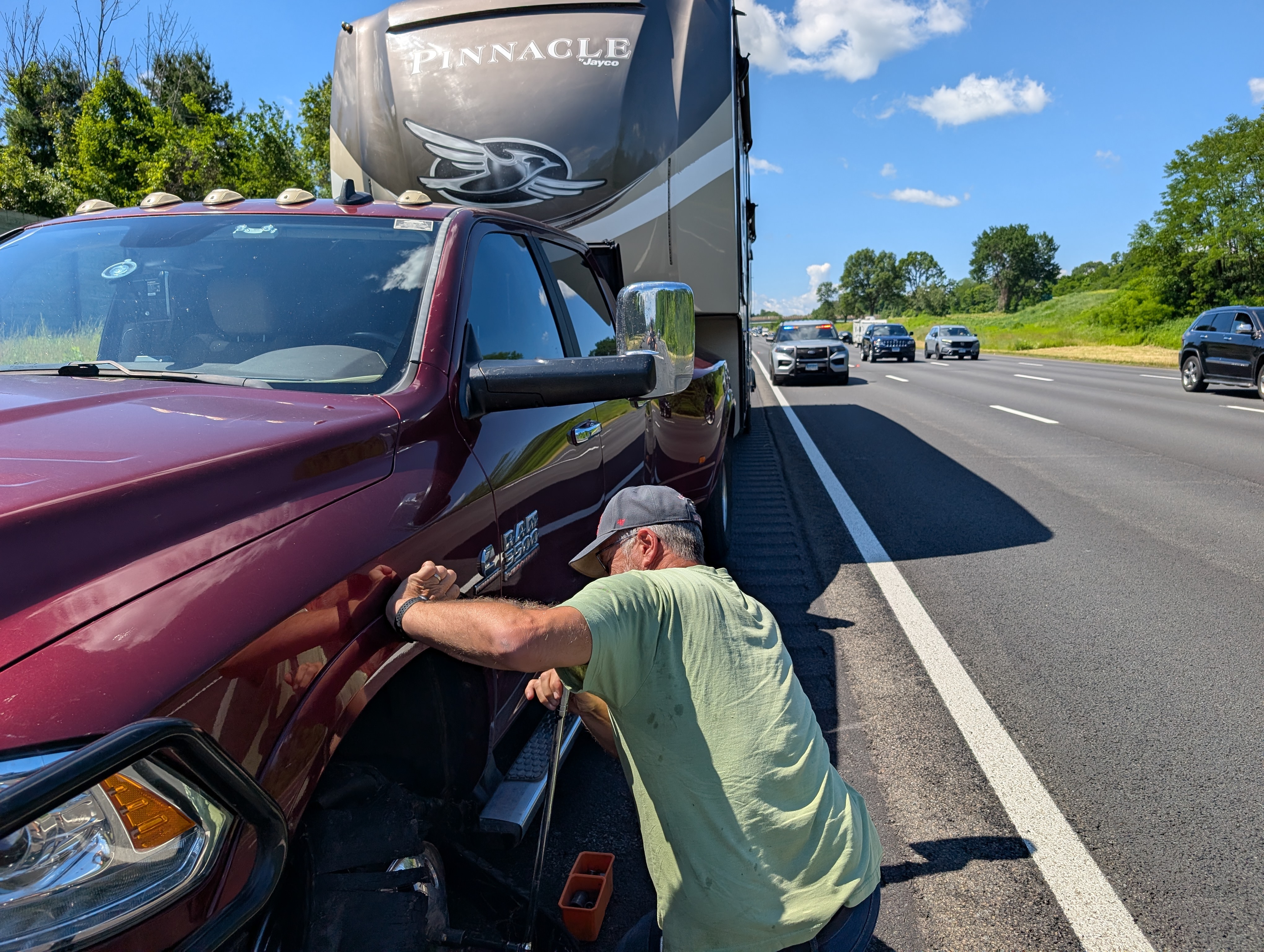 Bob working on the truck tire with a state cruiser blocking the right lane of traffic