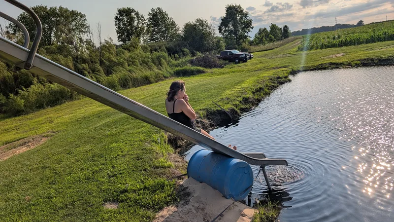 Woman gliding down a metal slide into water