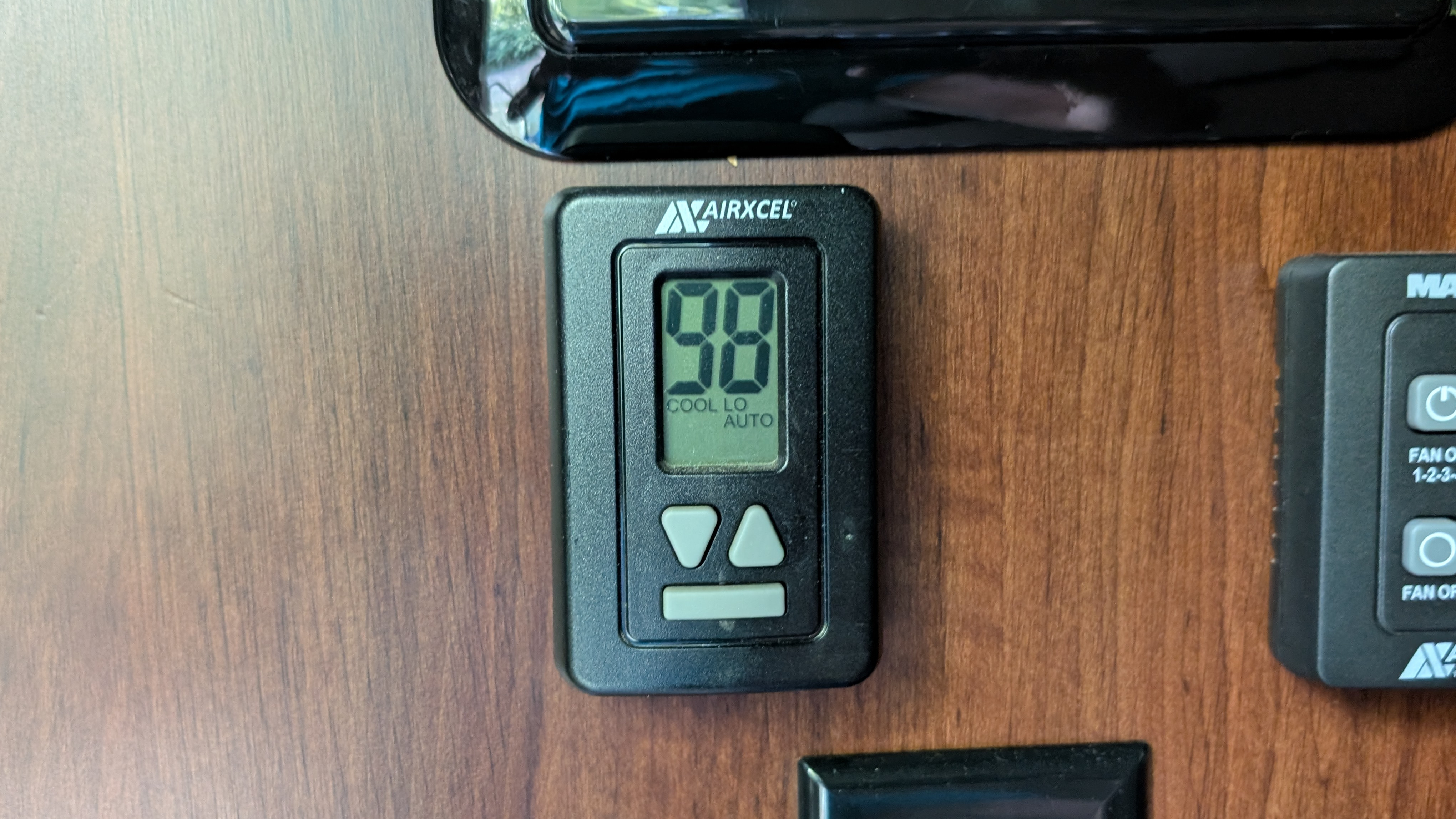A digital thermostat displaying 98