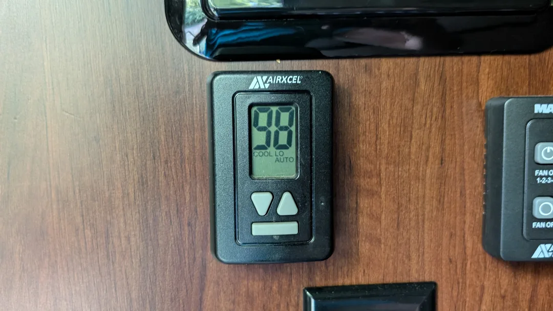 A digital thermostat displaying 98