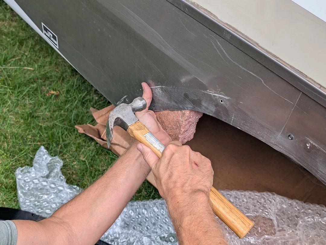 Hammering dents out of a trailer